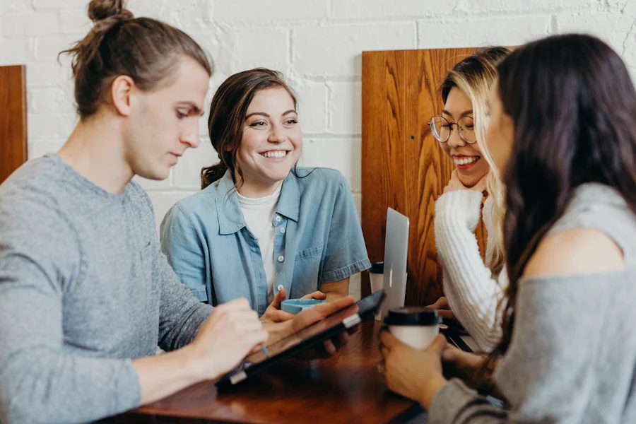 Housemates talking and laughing around a shared table in a co-living home