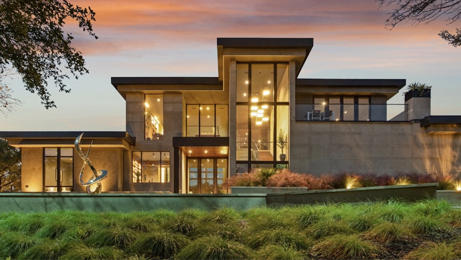 A finished, high-end modern home glowing with warm light at dusk