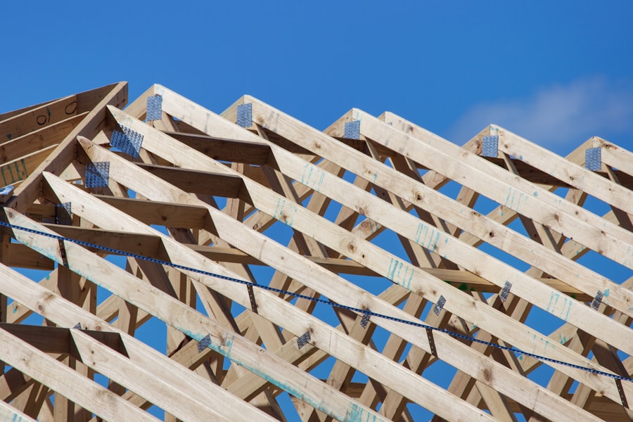Timber roof trusses under construction against a clear blue sky