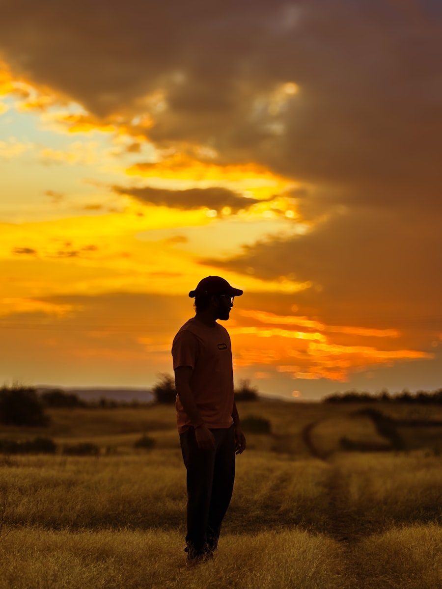 A person standing in an open grass block at golden hour
