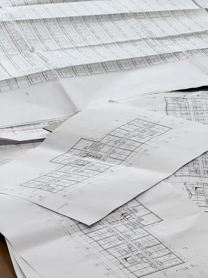 Architectural floor plans and blueprints spread out on a table