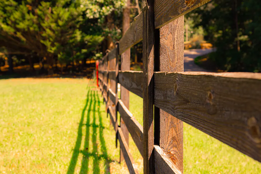 Empty grass land block bordered by a wooden fence line